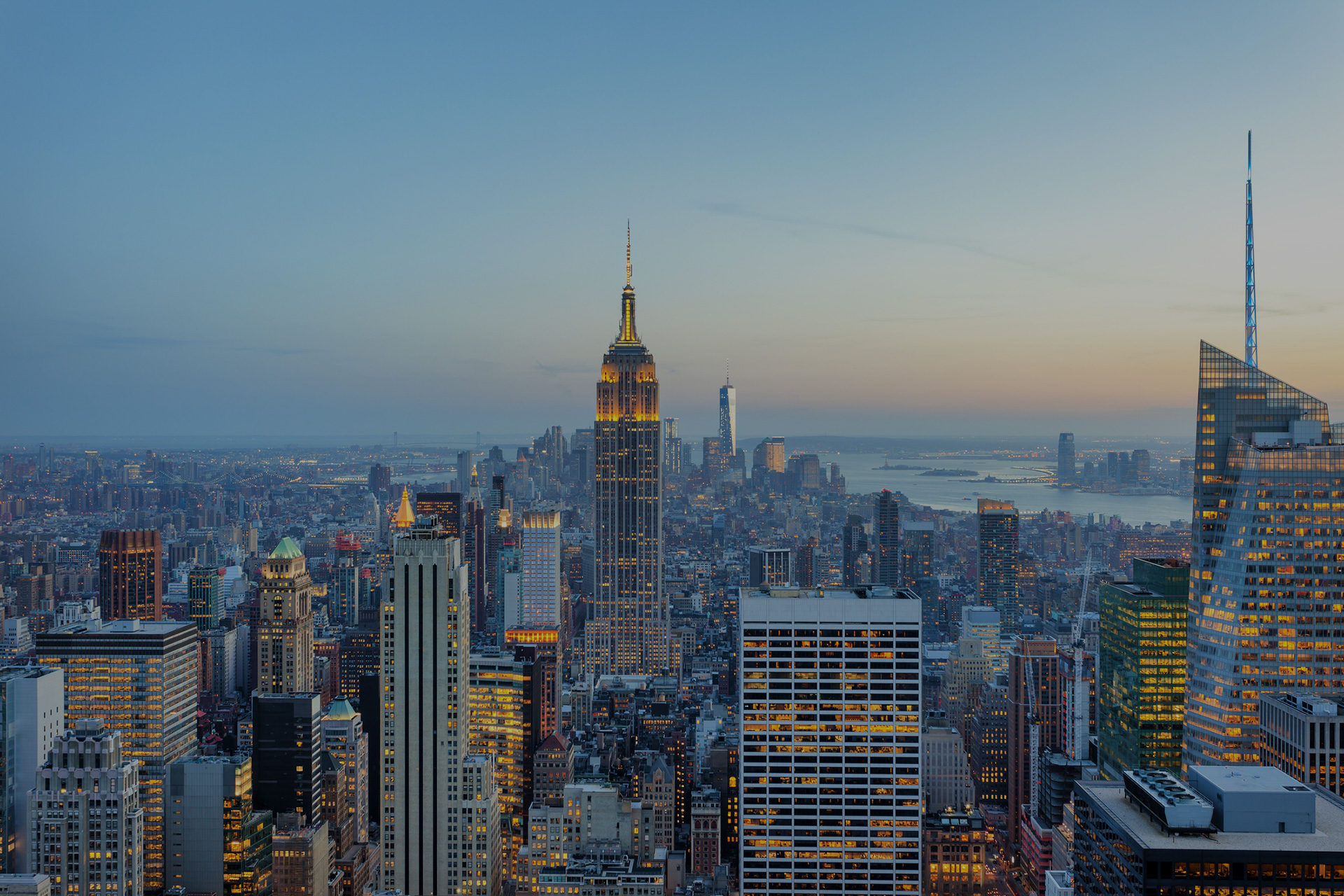 Panorama emblématique de Manhattan au crépuscule, avec ses gratte-ciel scintillants et l'Empire State Building illuminé