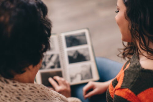 Une jeune femme et sa mère regardent un album photo 