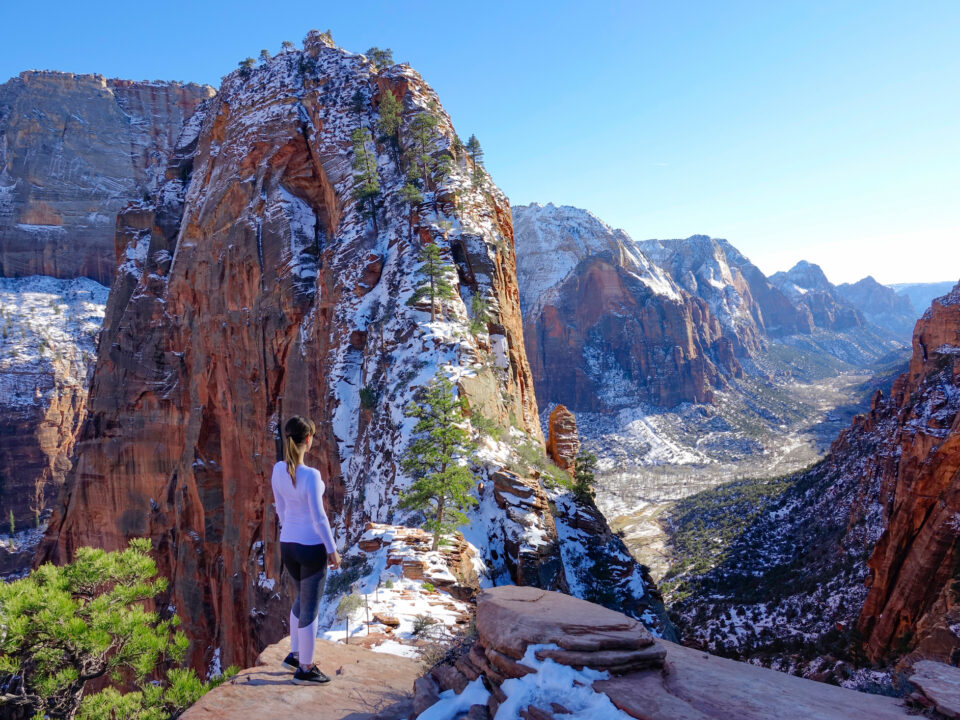 une jeune femme observe le parc national de zion sous la neige