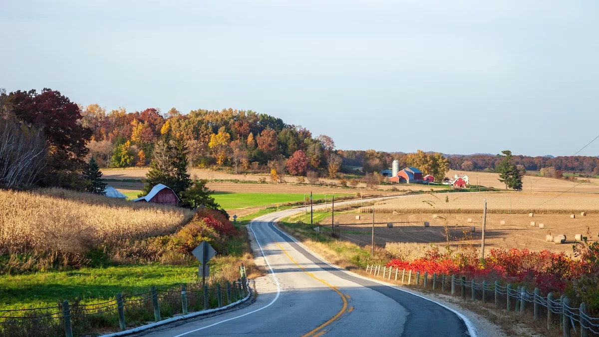 Route sillonnant la campagne dans le Wisconsin avec fermes rouges typiques de la région