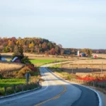 Route sillonnant la campagne dans le Wisconsin avec fermes rouges typiques de la région
