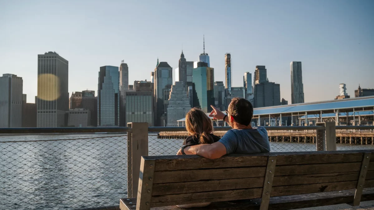 couple sur un banc regardant la skyline de manhattan