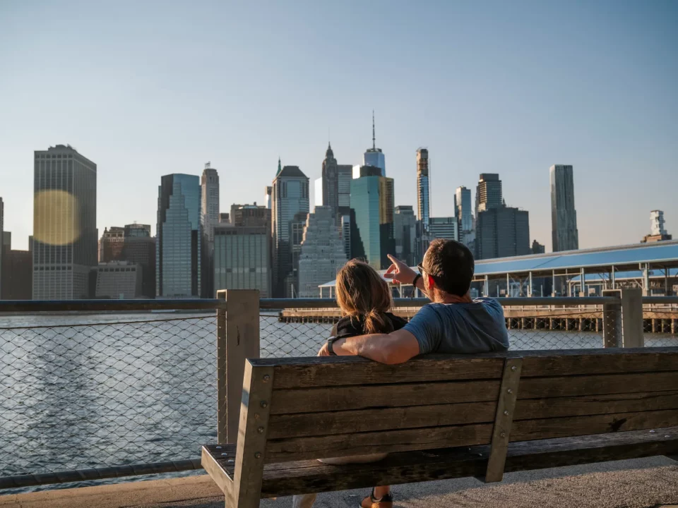 couple sur un banc regardant la skyline de manhattan