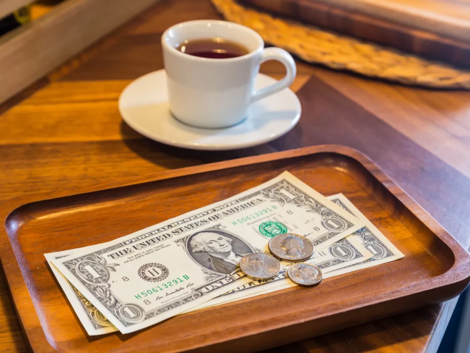 des dollars laissés sur une table en guise de pourboire dans un bar restaurant américain